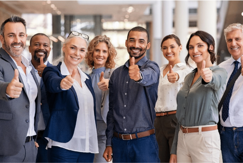Equipo de trabajo diverso sonriendo y haciendo el gesto de pulgar arriba en una oficina moderna.