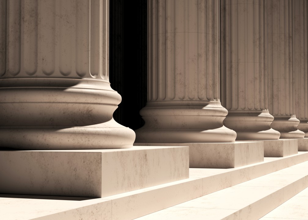 Vista en perspectiva de las bases y filas de columnas de estilo clásico o neoclásico sobre una escalinata de piedra.